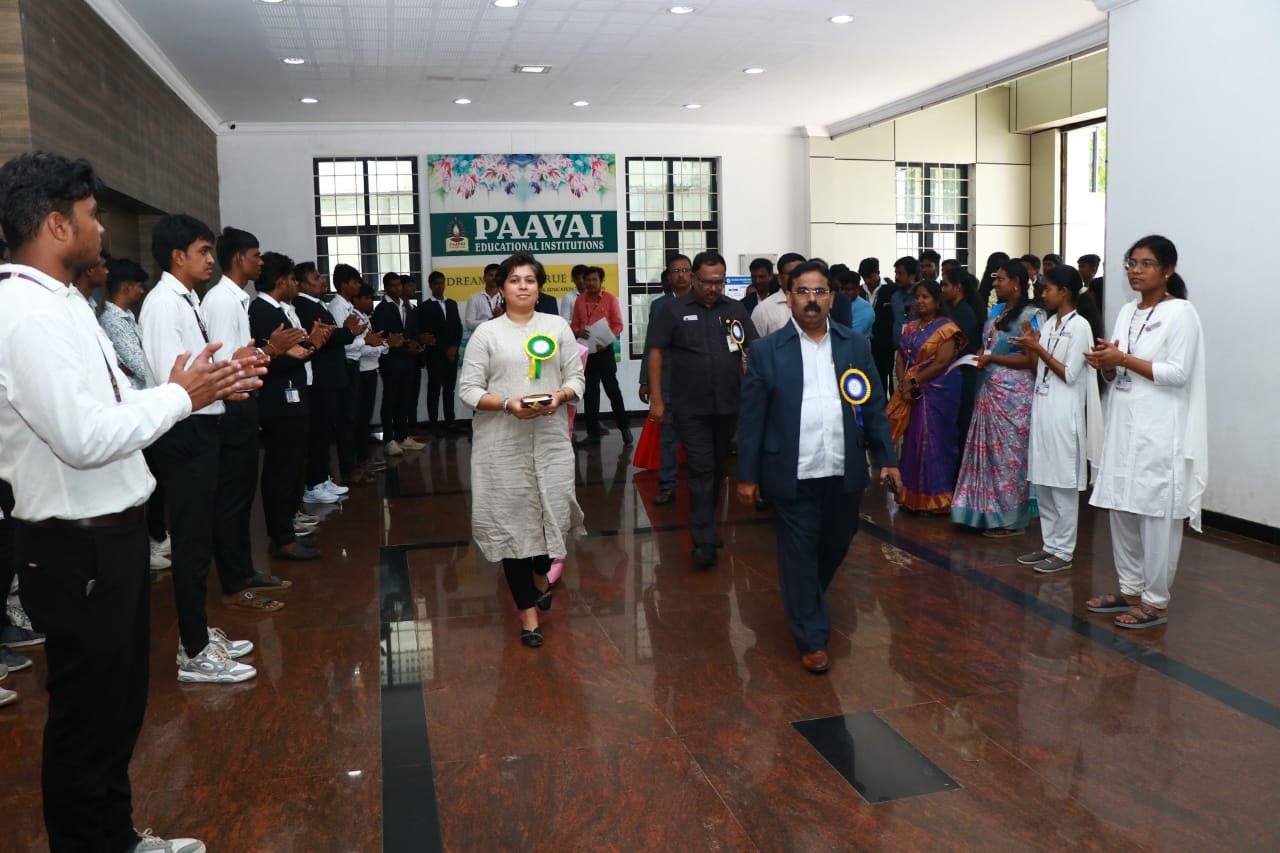Sanjana Rathi walking in through applauding students and faculty at Paavai