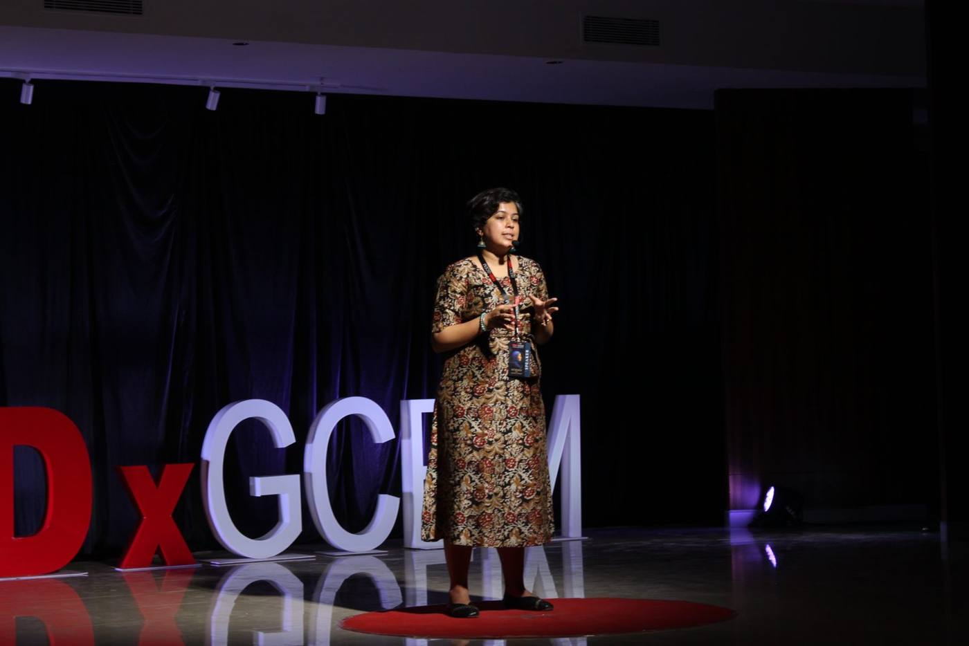 Sanjana Rathi speaking on the red circle at TEDxGCEM