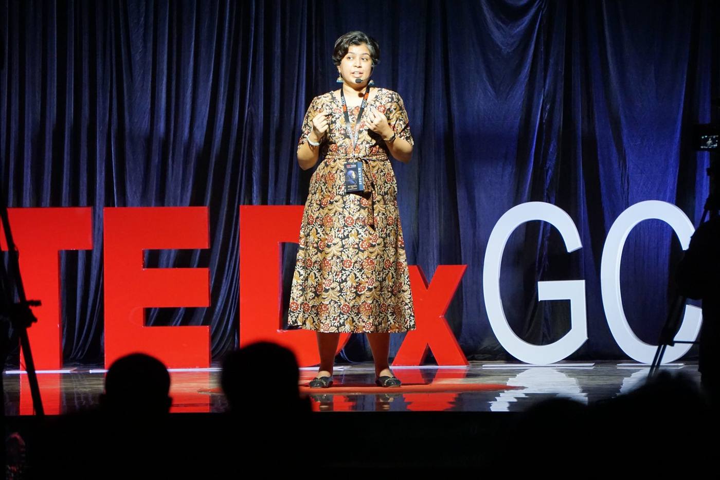 Sanjana Rathi on the TEDxGCEM stage with the audience in the foreground